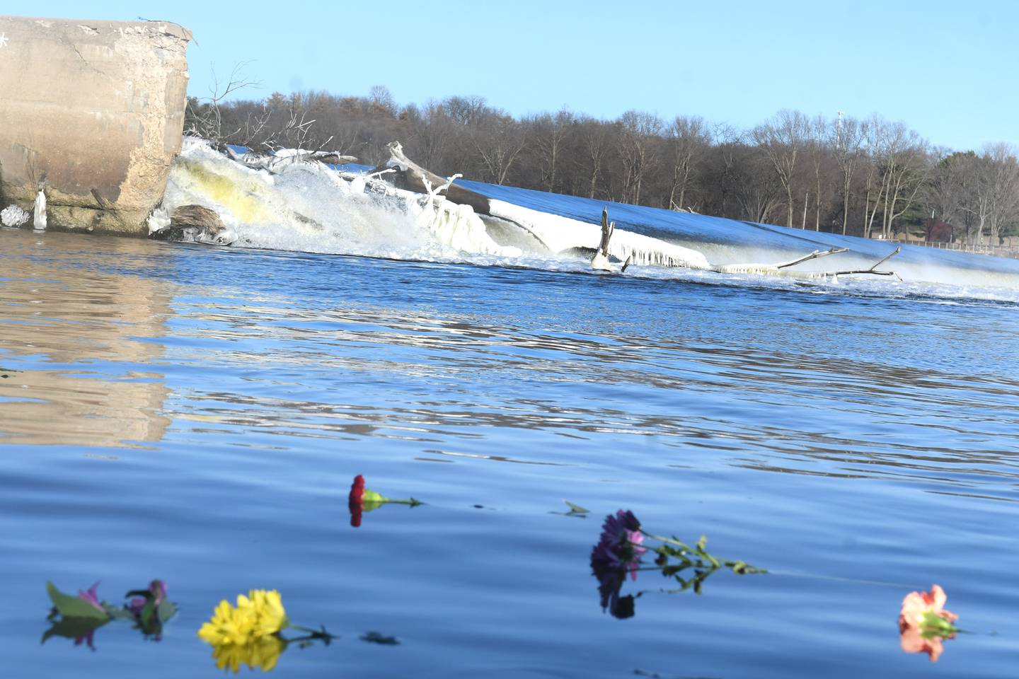 Flowers float in the Rock River at the base of the Oregon dam on Sunday, after family and friends of J=Kent Dearborn, Jr. marked the third anniversary of the fatal boating accident. Dearborn's body has yet to be found.