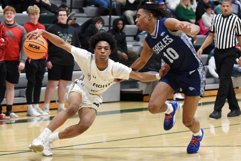 Bishop McNamara's Willie Felton, left, dribbles past Hope Academy's Trentyn McGinnis during a boys basketball game at Bishop McNamara Tuesday, Feb. 11, 2025.