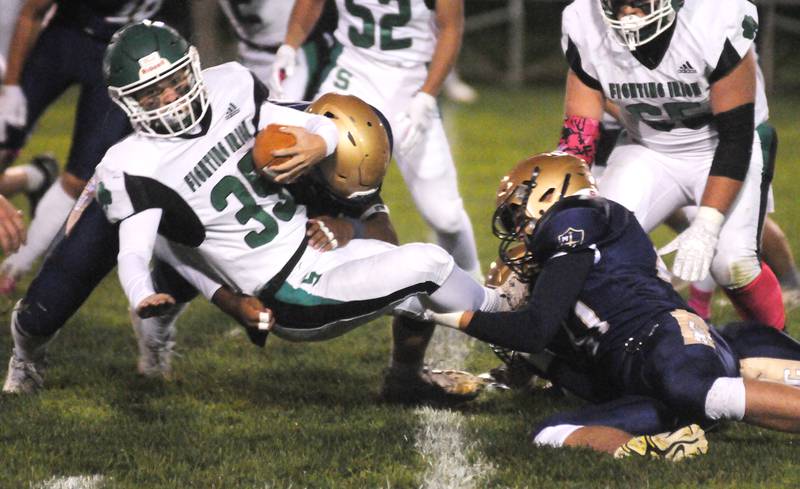 Seneca's Nathan Neal (35) is taken down by Marquette's Marcus Baker and Keaton Davis at Gould Stadium on Friday, Oct. 6, 2023.