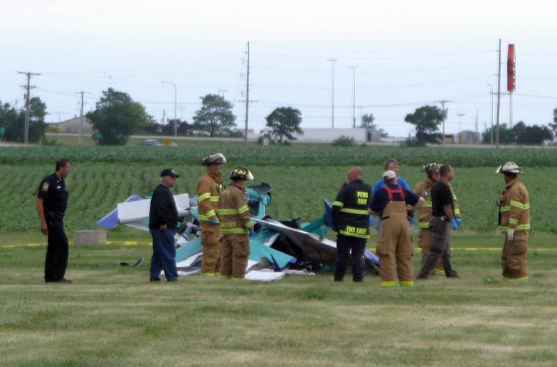 Crews work the scene of a airplane crash on Sunday June 18, 2006 during the Illinois Valley Air Show at the Illinois Valley Regional Airport in Peru. The pilot died after striking another aircraft in mid-air. The two planes, both RV Series kit aircrafts, were flying in formation with two other planes when they made physical contact with each other 800-1,000 feet above ground.