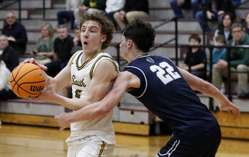 Cary-Grove's Adam Bauer (right) tries to knock the ball away from Crystal Lake South's Carson Trivellini (left)  during the IHSA Class 3A Prairie Ridge Regional championship basketball game on Friday, Feb. 28, 2025, at Prairie Ridge High School in Crystal Lake.