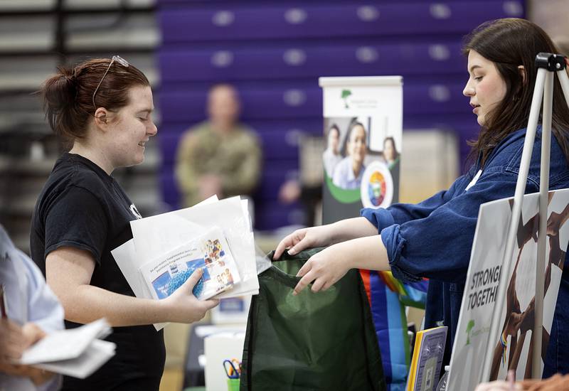 Halley-Anne Moore (left) accept materials from Sinnissippi Centers recruitment specialist Kali Worrell Wednesday, March 13, 2024 during a career fair hosted by Discover Dixon.