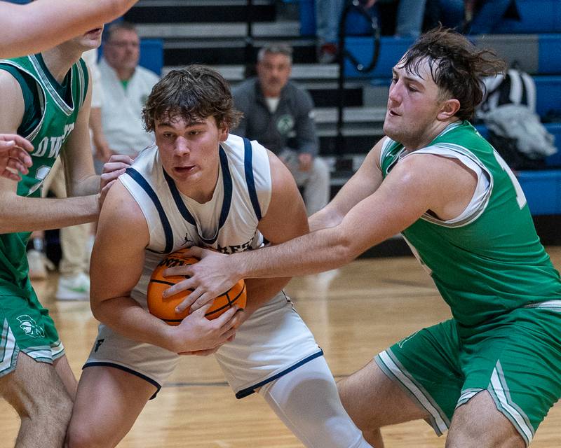 Drew Overocker (31) of Fieldcrest hugs ball as Evan Cox (10) of Dwight attempts to strip it from his possession on Monday, December 15, 2025 at Fieldcrest High School in Minonk.