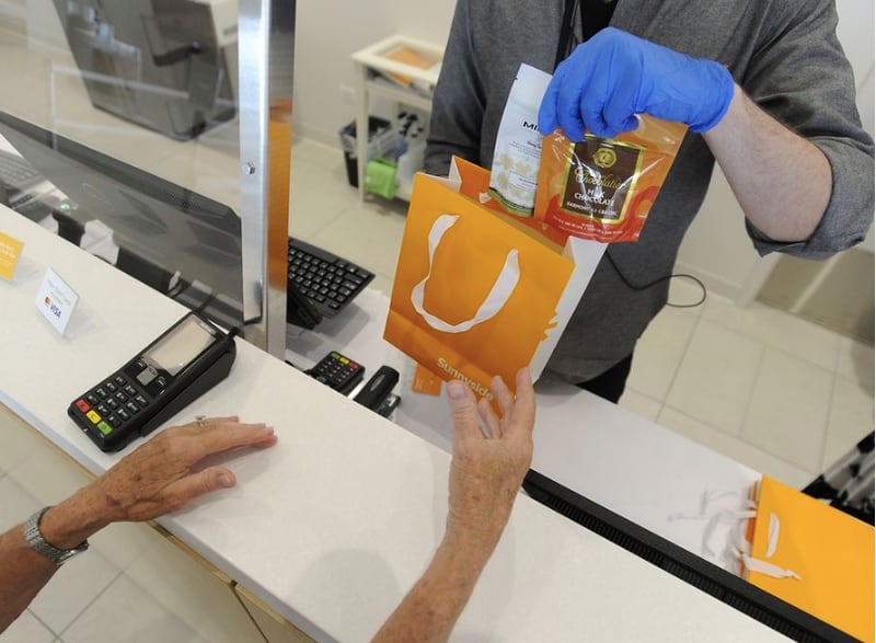 A customer picks up her order from a cannabis store in Schaumburg across from the Woodfield Mall. Glen Ellyn has opted out of recreational marijuana sales. (Mark Welsh | Staff Photographer, August 2020)