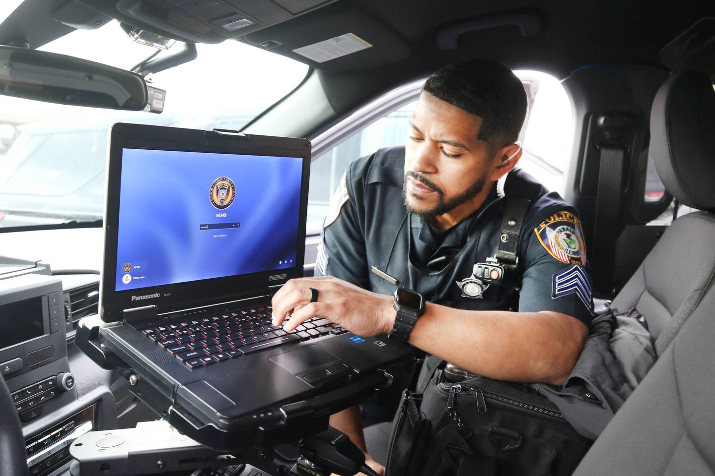 DeKalb Police Sgt. Raynaldo Hernandez signs in to the computer in his squad car as he prepares to start his shift Thursday, April 11, 2024, behind the DeKalb Police Department.