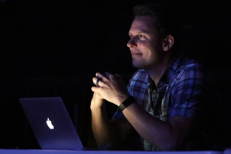 Director Derek Galvicius is illuminated by his laptop as he watches cast and crew work on a dress rehearsal for their upcoming performance of "Musical Revue" at McHenry High School West Campus on Thursday, March 4, 2021 in McHenry.  The musical opens on Friday, March 12 at 7pm, and will have performances on Saturday, March 13 at 4:30pm and 7pm, Sunday, March 14 at 3pm, Friday, March 19 at 7pm, and Saturday, March 20 at 7pm. All performances will be in-person at the theater under reduced capacity of 50 spectators.