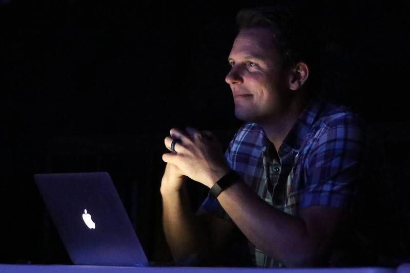 Director Derek Galvicius is illuminated by his laptop as he watches cast and crew work on a dress rehearsal for their upcoming performance of "Musical Revue" at McHenry High School West Campus on Thursday, March 4, 2021 in McHenry.  The musical opens on Friday, March 12 at 7pm, and will have performances on Saturday, March 13 at 4:30pm and 7pm, Sunday, March 14 at 3pm, Friday, March 19 at 7pm, and Saturday, March 20 at 7pm. All performances will be in-person at the theater under reduced capacity of 50 spectators.