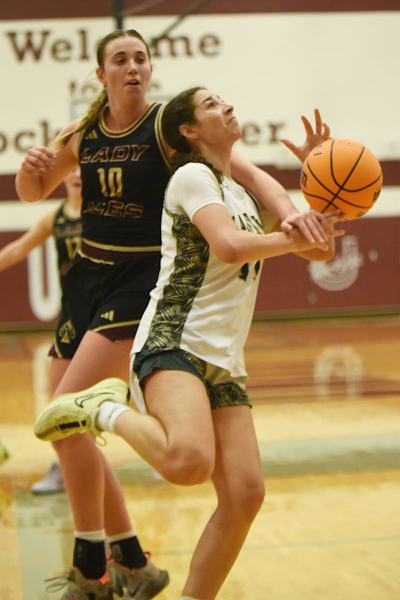Bishop McNamara's Trinity Davis, right, is fouled by Mt. Carmel's Madi Stevens during the IHSA Class 2A Tolono Unity Super-Sectional Monday, March 3, 2025.