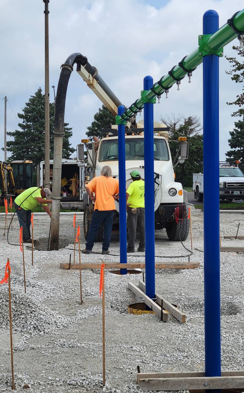 Workmen dig holes for the new playground equipment going in at Peck Park in Ottawa.