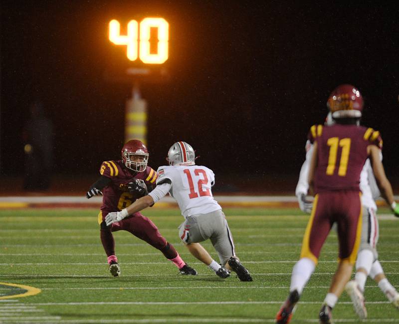 Schaumburg’s Omarion Jones makes a move in the open field against Palatine’s Aiden Wimer in a football game in Schaumburg on Friday, October 14, 2022.