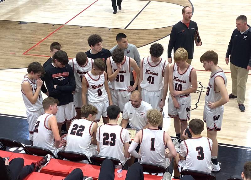 Woodland boys basketball coach Connor Kaminke (center) talks things over with his Warriors during a timeout Tuesday, Nov. 21, 2023.