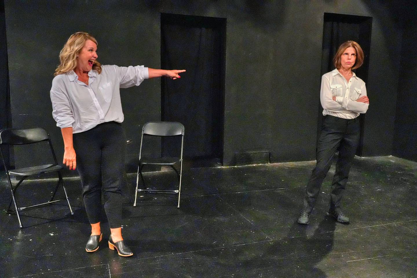 Diana (Beth Goncher) has a good laugh at the expense of Rachel (Jen Connon), who doesn't appreciate the joke in "The Second-to-Last Exit" at Village Theatre Guild [L to R: Beth Goncher, Jen Connon]