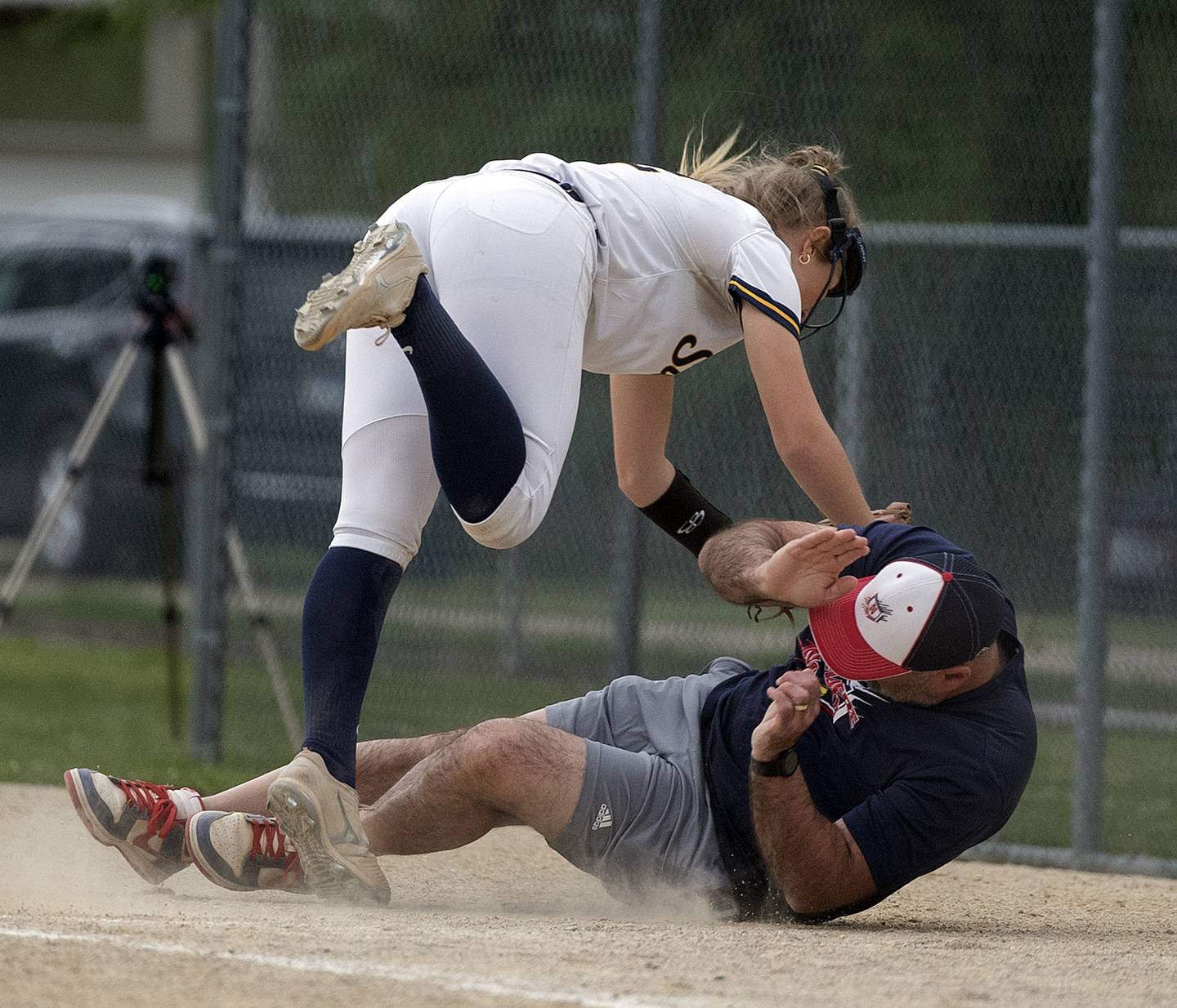 Sterling’s Georgia Gallardo crashes into the Belvidere North first base coach while chasing a foul ball Friday, May 30, 2025, in the Class 3A Regional final in Dixon. The batter was called out on the play.