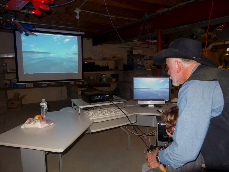 Jim Archer of the United Church of Christ RC Club (right) shows Juliano Wright of Shabbona how to use a flight simulator during the open house wellness event of the United Neighborhood Center in Shabbona on Saturday, Sept. 20.