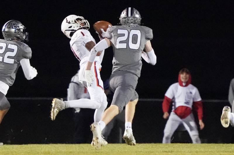 Oswego’s Jeremiah Cain (1) catches a pass against Oswego East's Andrew Pohlman (20) during a football game at Oswego East High School on Friday, October 25, 2024.