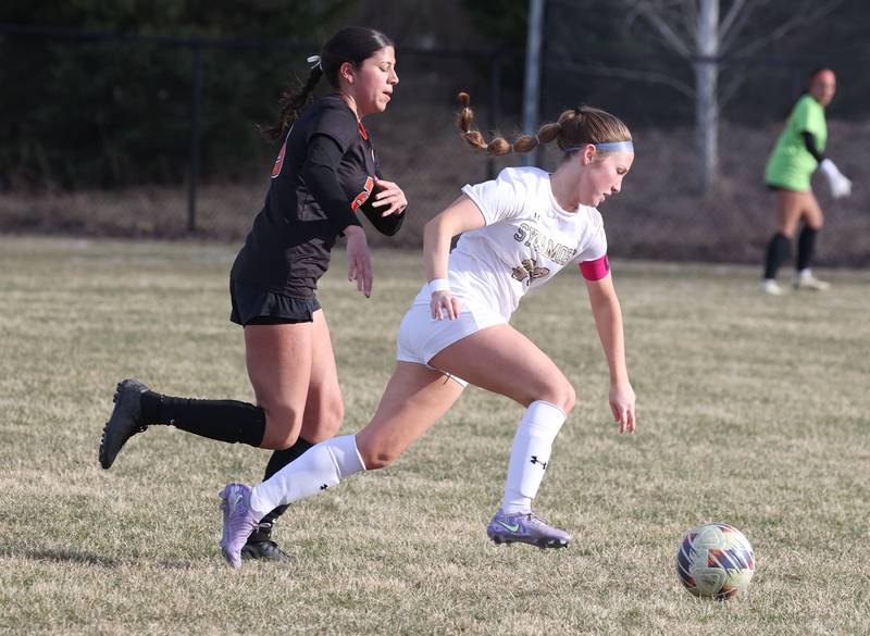 Plainfield East's Gabriella Sanchez (left) and Sycamore's Cortni Kruizenga go after a loose ball during their game Tuesday, March 25, 2025, in the Barb Fest tournament at DeKalb High School.