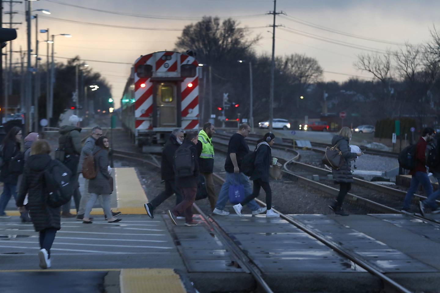 People walk to their cars after getting off a Metra train from Chicago on Tuesday, Feb. 14, 2023, at the Crystal Lake Metra station in downtown Crystal Lake.