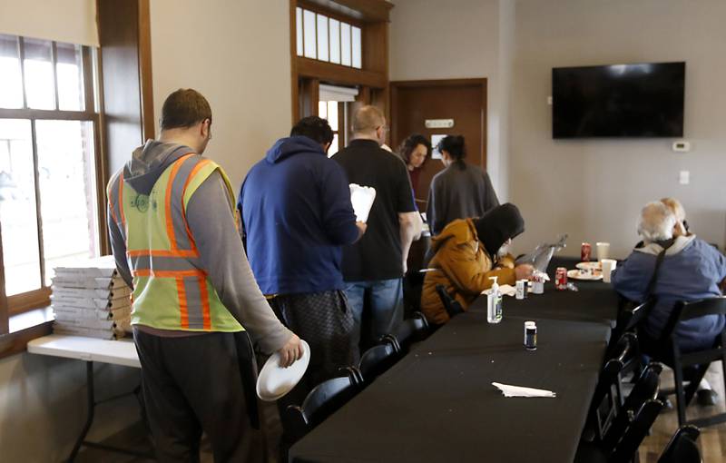 People wait in line to get food during a free pre-Thanksgiving luncheon on Wednesday, Nov. 22, 2023, at the Woodstock train depot. This is the second year the meal that was provided through efforts of Warp Corps, MBI Cares, Isabel’s Family Restaurant, and Napoli’s Pizza, all located in Woodstock
