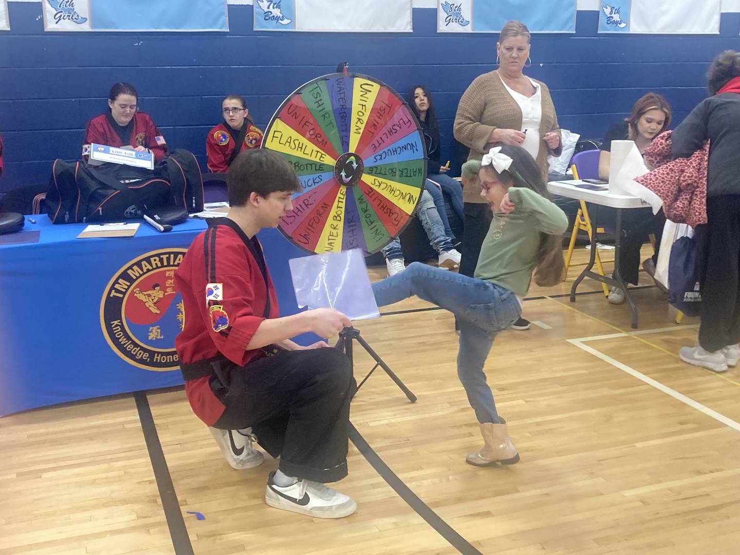Amaya Broyles takes a mini lesson at the booth run by TM Martial Arts Academy at Troy Middle School in Plainfield on Monday, Feb. 17, 2025.
