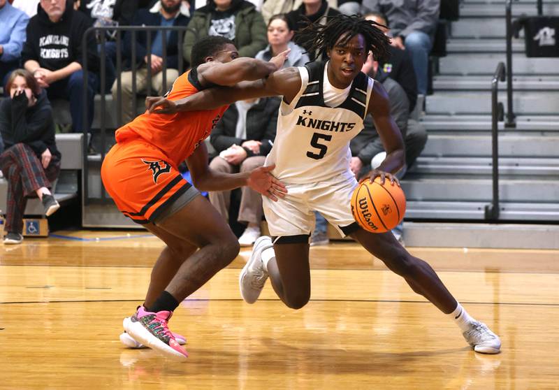 Kaneland's Fredrick Hassan goes baseline against DeKalb's Davon Grant during their game Tuesday, Jan. 28, 2025, at Kaneland High School in Maple Park.