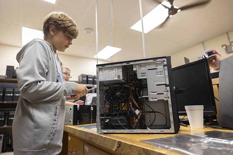 Jesse Horton, 12, works to remove the panel from a computer during the computer science camp Thursday, July 13, 2023 at WACC.