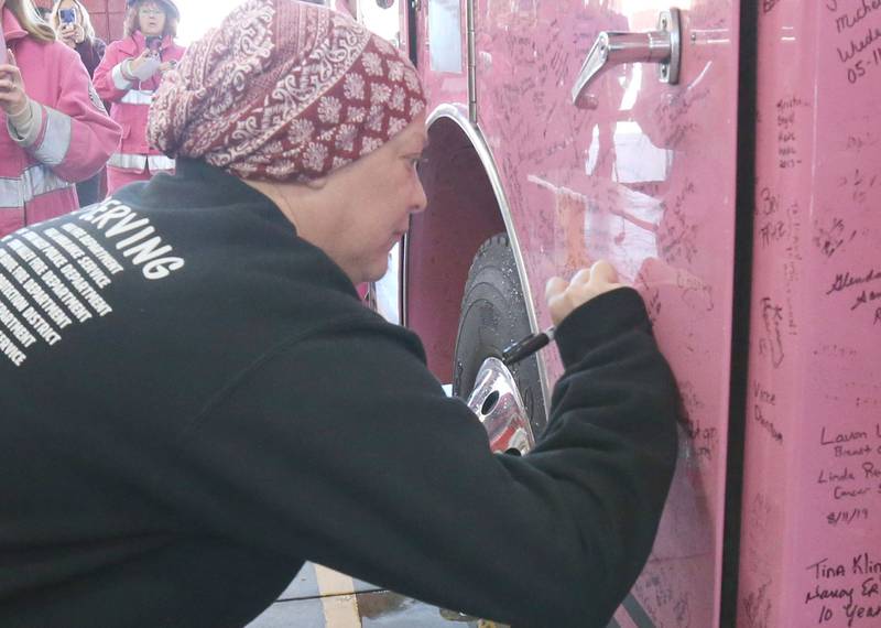 Rachel Sienkiewicz signs the Pink Heals Firetruck on Thursday, Feb. 13, 2025 at the Peru Fire Station. Sienkiewicz is a telecommuicator at the Illinois Valley Regional Dispatch Center in Peru, who is battling uterine cancer. The Pink Heals Sauk Valley Chapter is a non profit providing communities with a program that supports people on a personal level in partnership with the public safety and local businesses.
