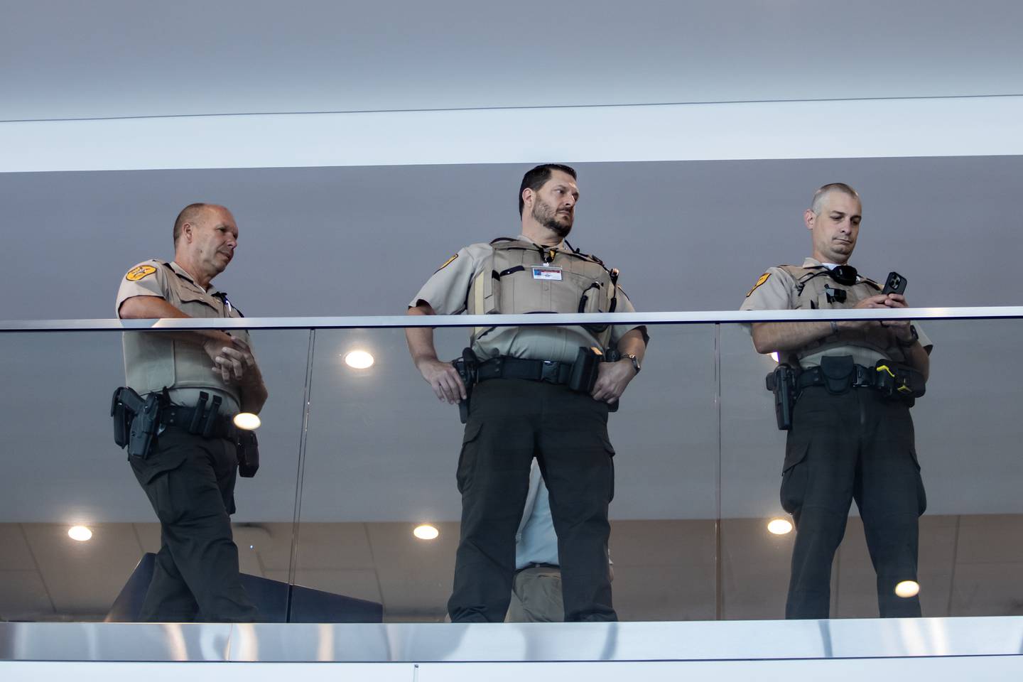 Members of law enforcement observe the opening of the 'Portrait of a Soldier' exhibit from the second floor at the Will County Courthouse in Joliet, Illinois on Sept. 11, 2025.