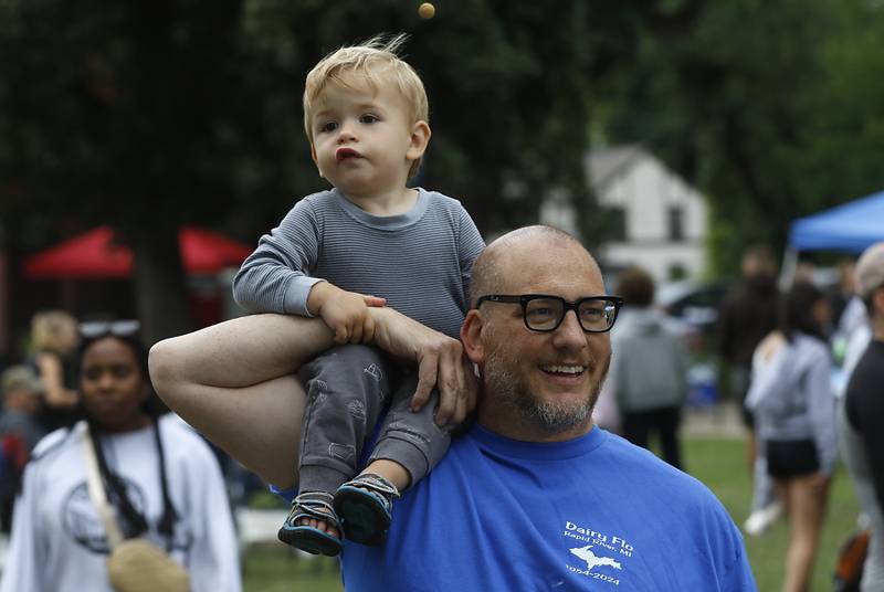 Magnus Schweitzer, 21 months, rides on the shoulder of his dad, Ed, as they walk around the Ice Cream Fest on Friday, Aug. 9, 2024, at Crystal Lake’s Main Beach.  The second annual event featured music, ice cream venders and an ice cream eating contest.