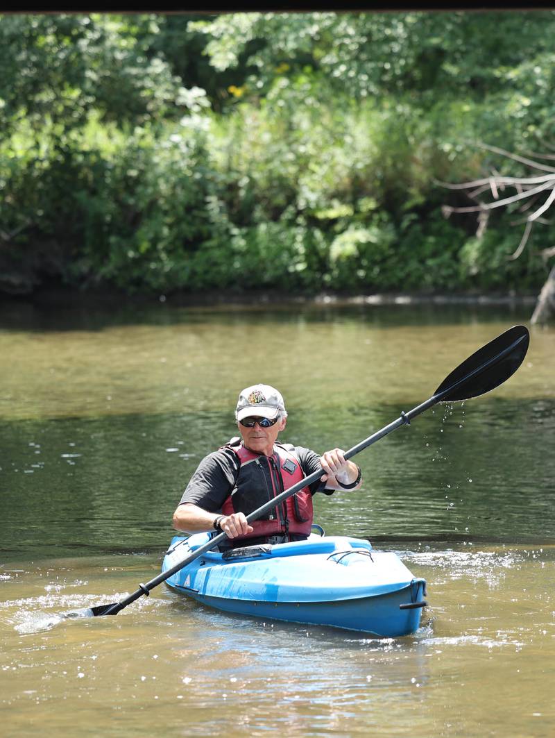 Greg Romaneck kayaks Thursday, Aug. 10, 2023, in the Kishwaukee River at the Knute Olson, Jr. Forest Preserve in Kingston. Romaneck has been making regular visits to pick up trash as he paddles the river and been an advocate for keeping the river and its surroundings free of pollution.