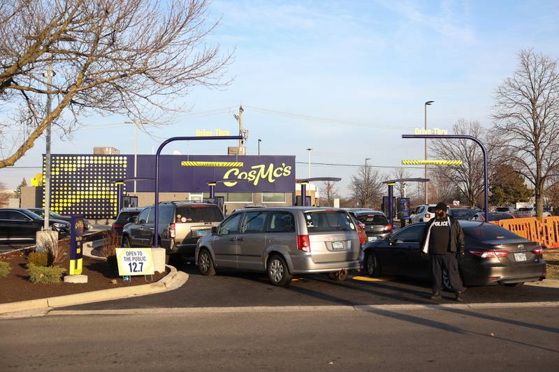 A police officer directs traffic as vehicles pull up to CosMc’s, McDonald’s first small format beverage driven concept drive-thru restaurant, on Friday, Dec. 8, 2023, in Bolingbrook.