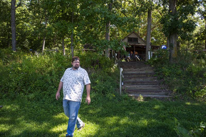 Owner Tim Benedict walks down to the banks of the Rock River that runs in front of the structure.