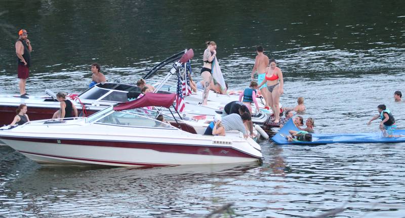 Boaters tie off to one another on the Illinois River for the Independence Day fireworks on Thursday, July 3, 2025 in Peru.