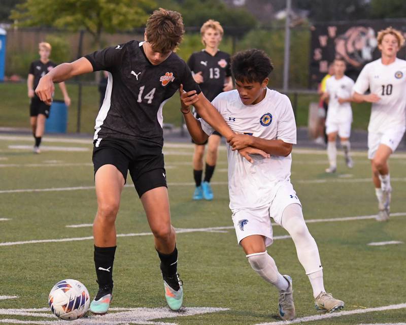 Wheaton Warrenville South's Tyler Luetkehans (14) and Wheaton North's John Thawng (7) battle for the ball during the game on Thursday Sept. 11, 2025, held at Wheaton Warrenville South.