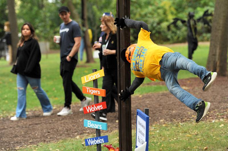 Fest goers take a walk scarecrow path and admire an entry by Cub Scout Pack 340 during Yorktoberfest, Saturday, Sept. 28, 2024, in Riverfront Park in Yorkville.