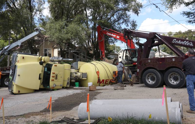 Crews with Scholles Body Shop use tow trucks to lift a cement truck out of a sinkhole on Tuesday, Sept. 2, 2025 at the intersection of Pulaski Street and 6th Streets in Peru.