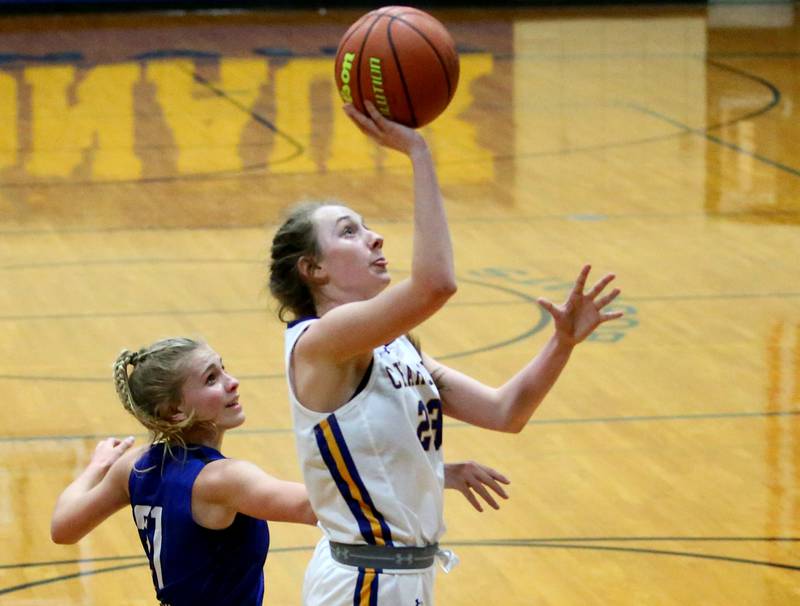 Aurora Central Catholic's Riley Cwinski (23) cuts in front of Newark's Addison Ness (21) to score a basket in the Tim Humes Breakout Tournament on Friday, Nov. 18, 2022 in Somonauk.