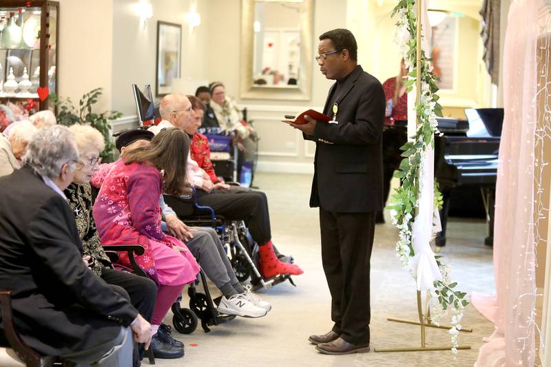 Chaplain Reginald Sey officiates the renewal of wedding vows for (from left) Richard and Christine Garcia, Marcia Whitney-Schenck and Robert Schenck and Sherri and William Bowne on Friday, Feb. 14, 2025 at Churchill Place, an Anthem Memory Care community in Glen Ellyn.