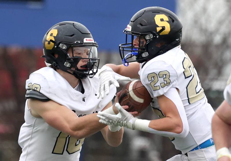 Sycamore's Burke Gautcher hands the ball off to Dylan Hodges Saturday, Nov. 9, 2024 during their Class 5A second-round playoff game against Westinghouse at Knute Rockne Stadium in Chicago.