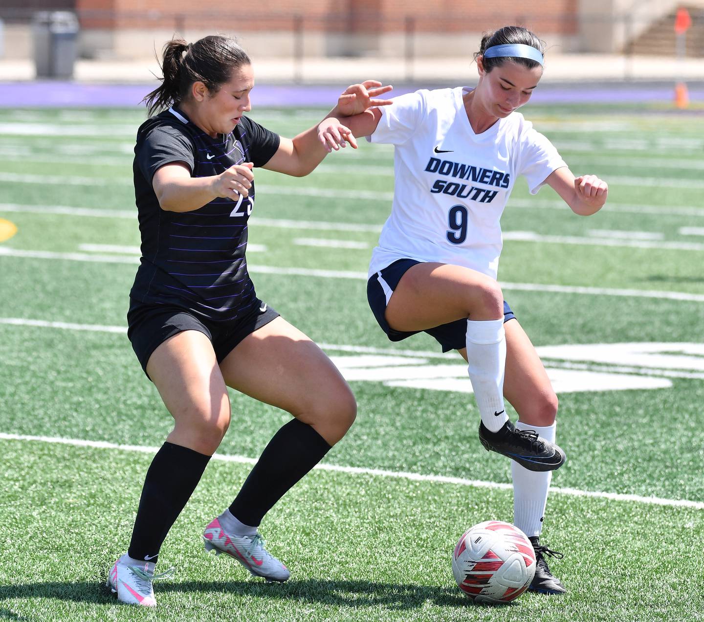 Gianna Lamb (9) does some fancy footwork as Downers Grove North’s Gianna Goodwin defends during a game on May 10, 2025 at Downers Grove North High School in Downers Grove .
