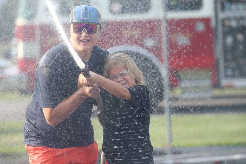 Owen Ponce competes in the water fights with the help of Spring Valley firefighter Donavon Soberalski during the National Night Out event on Tuesday, Aug. 1, 2023 at Kirby Park in Spring Valley.