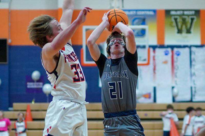 Oswego East's Andrew Pohlman (21) shoots the ball in the top of the key against Oswego's Graham Schwab (33) during a basketball game at Oswego High School on Tuesday, February 18, 2025.