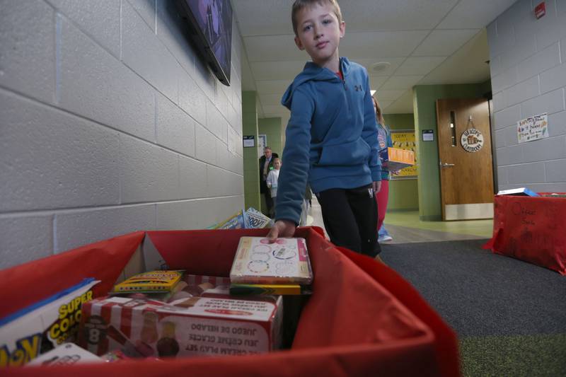 Jordy Bezely places toys into a bin during the Small School Big Hearts campaign at Dimmick School in La Salle. The “Small School, Big Hearts” campaign is a toy drive organizded by third graders and celebrates the power of kindness, generosity and community spirit. Gifts will be wrapped and sent to Officer Santa with the La Salle Police Department and St. Jude. The school is accepting donations through Dec. 12.