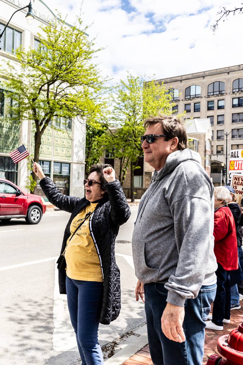 New Lenox residents Heidi and Joe Sullivan celebrate as cars honk in solidarity with the May Day Weekend Rally in Downtown Joliet on May 3, 2025.