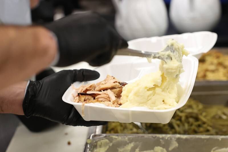 Marc Senffner prepares a to-go meal for a member of the community at the Daybreak Center on Thanksgiving Day in Joliet.