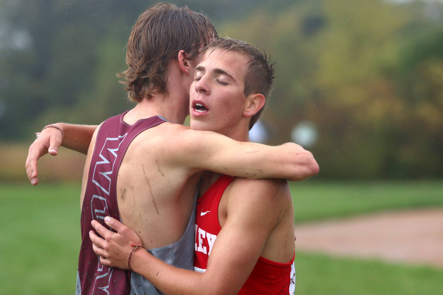 Prairie Ridge’s Will Gelo, left, embraces Huntley’s Tommy Nitz after the Fox Valley Conference Boys Cross Country Meet at Plato Park in Elgin Saturday.