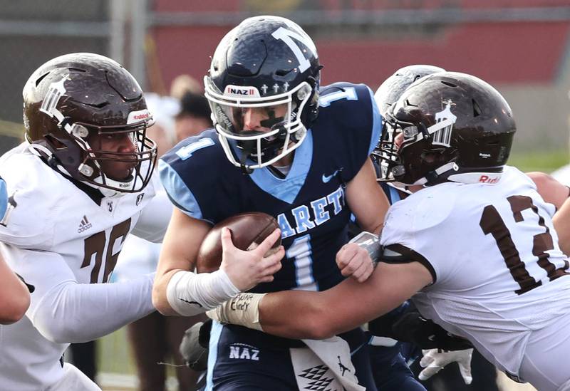 Nazareth's Logan Malachuk is wrapped up Joliet Catholic's Zach Pomatto Saturday, Nov. 25, 2023, during their IHSA Class 5A state championship game in Hancock Stadium at Illinois State University in Normal.