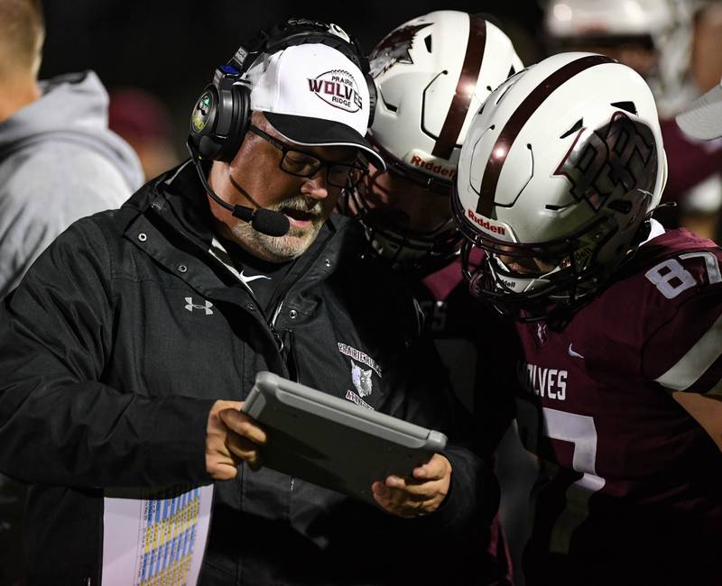 Prairie Ridge's Head Coach Chris Schremp talks with his players between plays in Friday night's game against Crystal Lake South at Prairie Ridge High School on October 15, 2021 in Crystal Lake, IL.