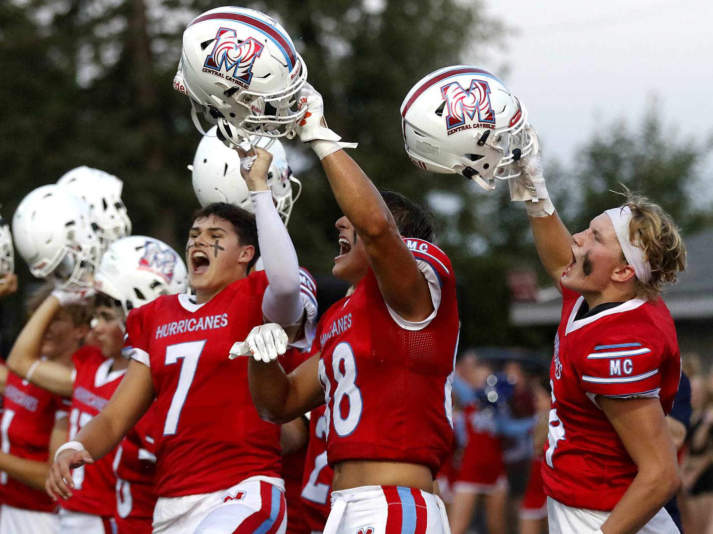 Marian Central's Cale McThenia, Christian Bentancur, and Marian Central's Tyson Jakubowicz yell as the raise their helmets before the start of a nonconference football game against Richmond-Burton Friday, Aug. 25, 2023, at Marian Central Catholic High School.