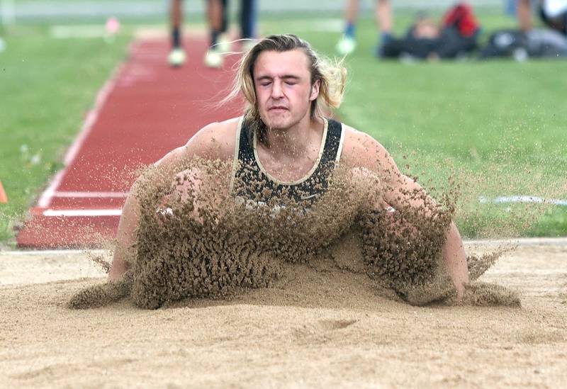 Sycamore's Pierce Reinhard lands in the pit in the long jump Wednesday, May 18, 2022, at the Class 2A boys track sectional at Rochelle High School.