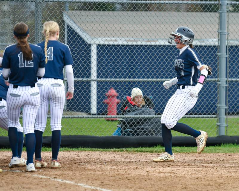 Oswego East's Danielle Stone, right, gets congratulated by her teammates after hitting a home run during the game on Thursday April 17, 2025, while taking on Plainfield North held at Oswego East.